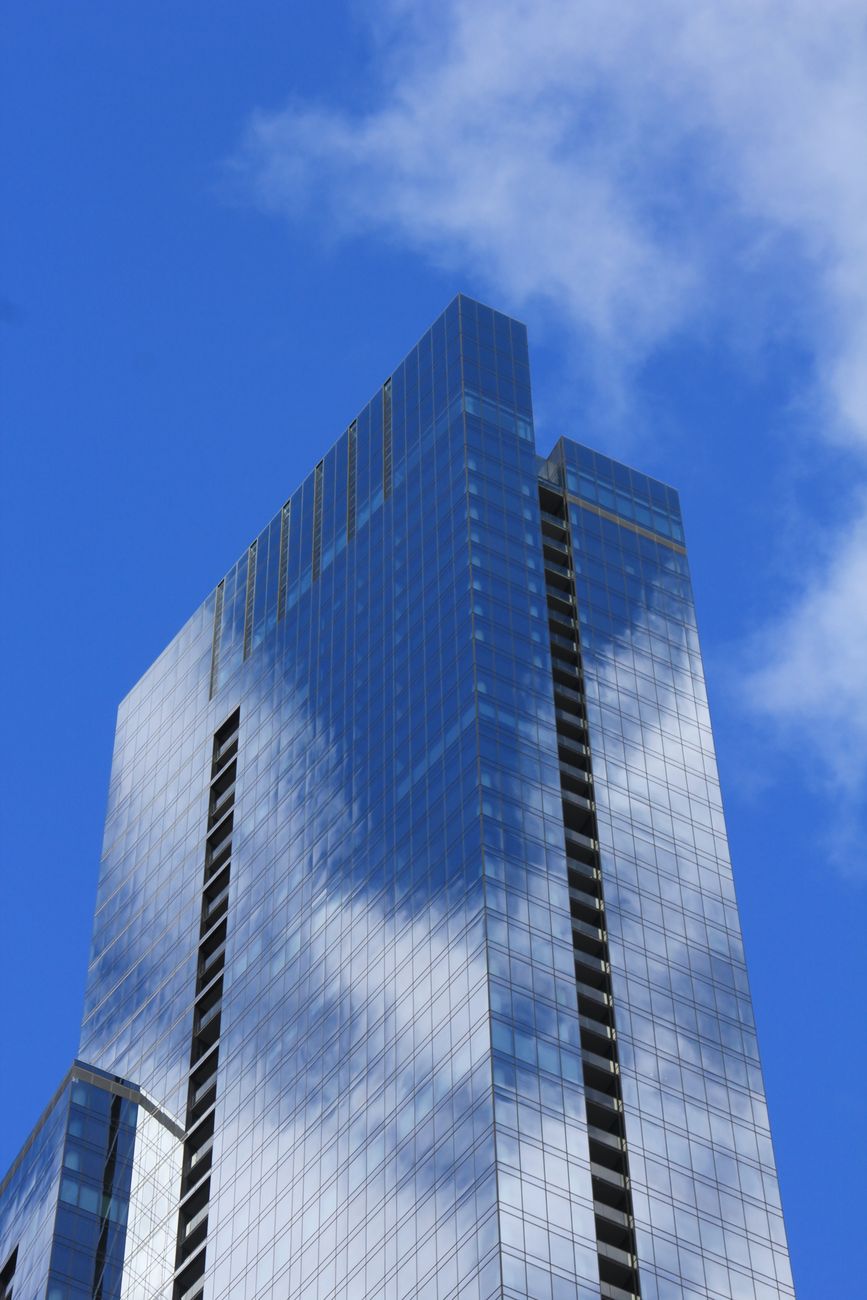blue sky and clouds over a skyscraper