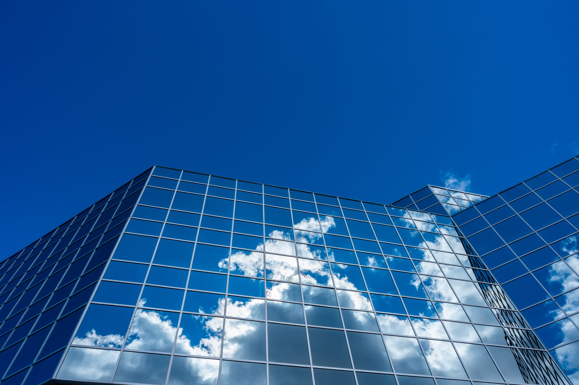 clouds reflecting on curtain wall building